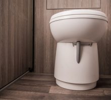 Close,up,of,white,toilet,in,tan,small,area,of